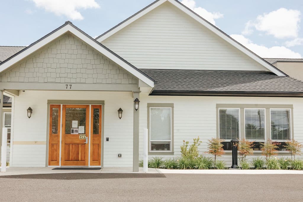 Front entrance and wood door of a cottage at Kinsington Oak Grove in Medford, Oregon