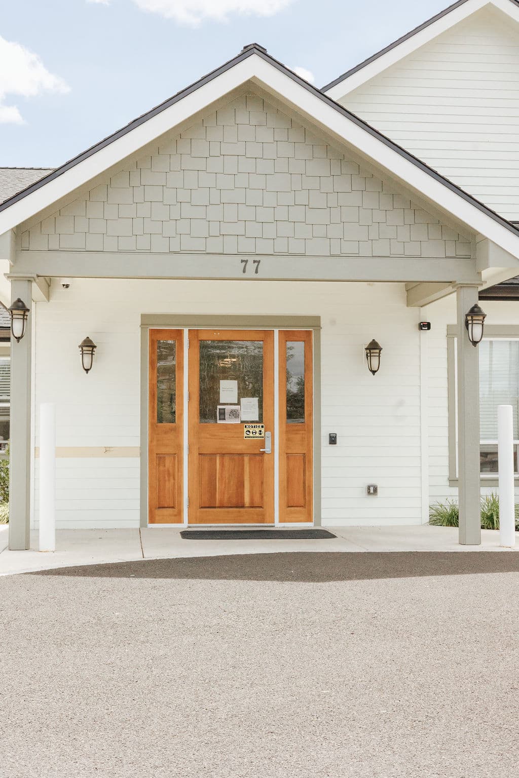 The wood-and-glass front doors of Oak Grove in Medford, under a covered entry marked 77