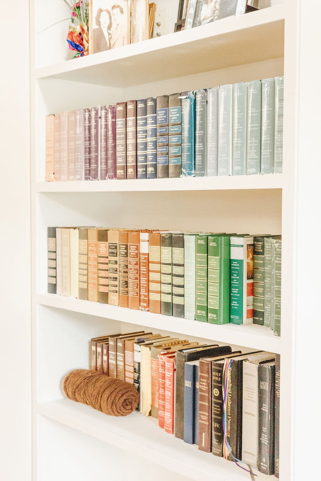 A book shelf filled with books and a roll of yarn